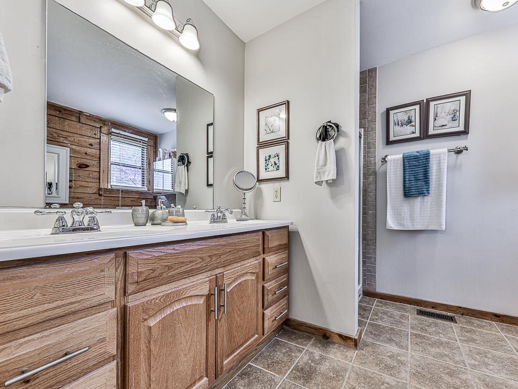 290 Ruby Lane Ellijay, GA 30540 - Photo 31 of 34 a spacious bathroom with a double vanity sink a mirror and shower