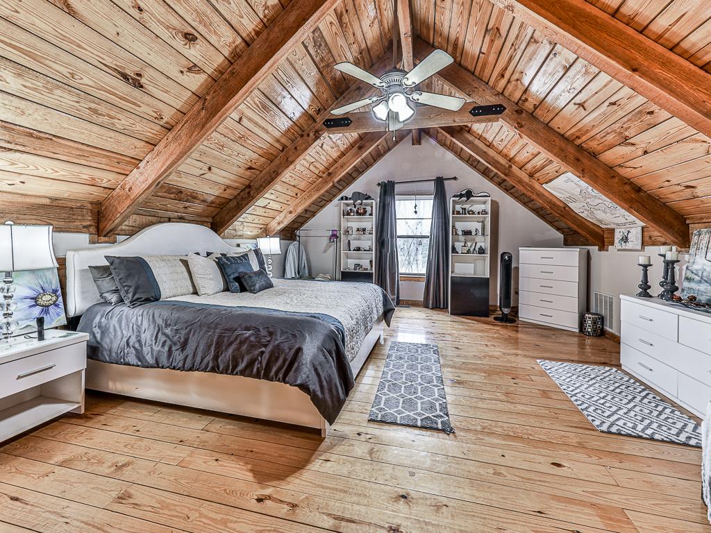 290 Ruby Lane Ellijay, GA 30540 - Photo 8 of 34 a spacious bedroom with a bed and a chandelier