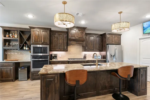 a kitchen with stainless steel appliances granite countertop a stove refrigerator and cabinets