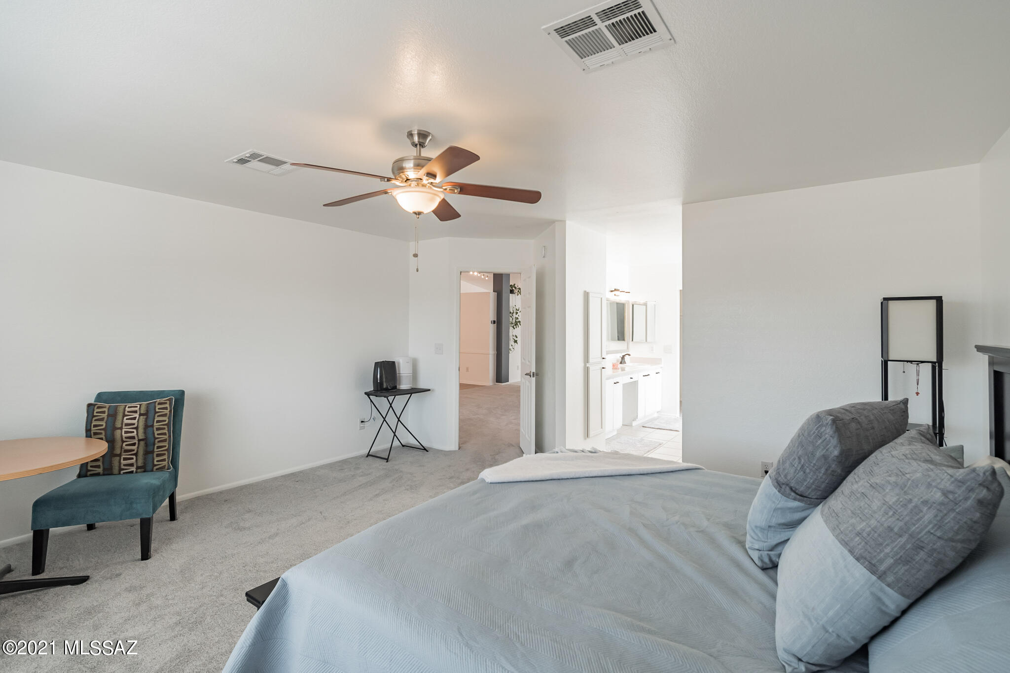 9671 East Azuma Way Tucson, AZ 85747 - Photo 14 of 31 a bedroom with a bed and a chandelier