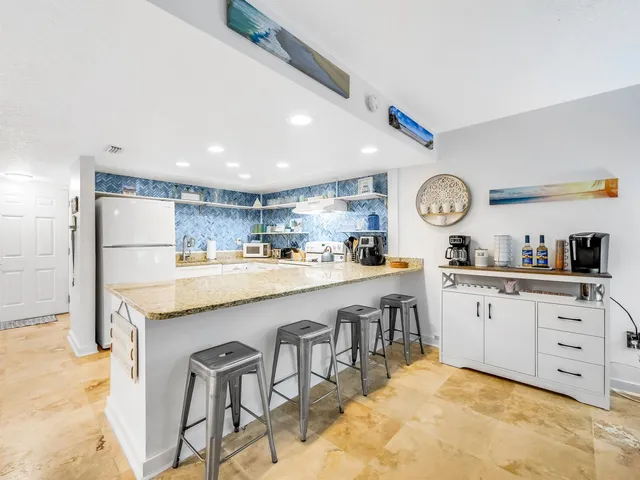 a large kitchen with stainless steel appliances granite countertop a sink and cabinets