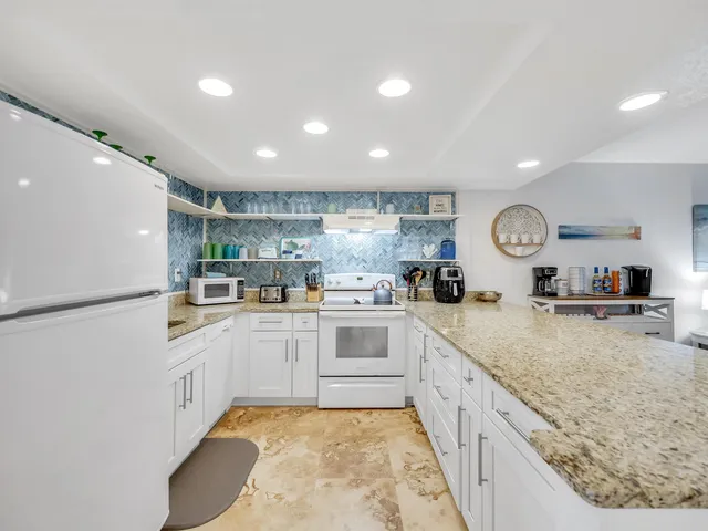 a kitchen with granite countertop a sink and cabinets