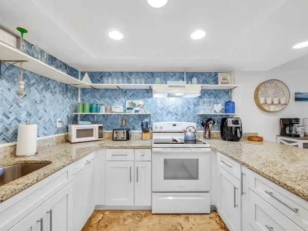 a kitchen with a sink a stove and cabinets
