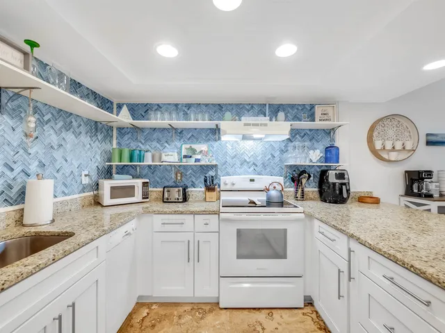 a kitchen with a sink a stove and cabinets