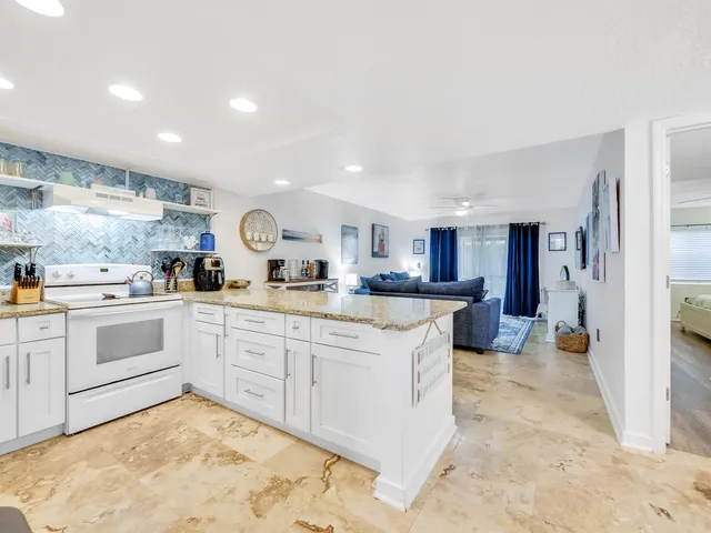 a living room with granite countertop furniture and kitchen view