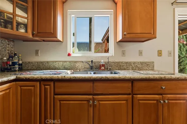 a kitchen with granite countertop a sink and cabinets