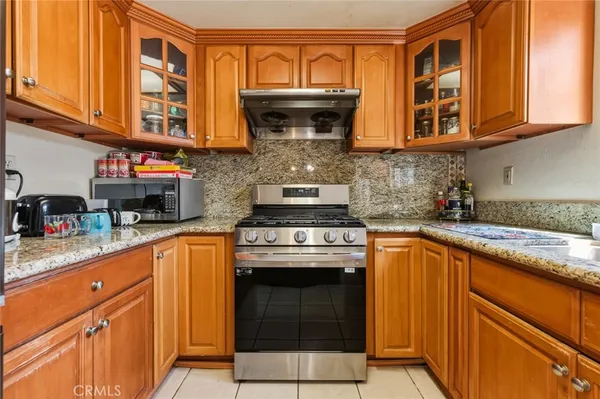 a kitchen with stainless steel appliances granite countertop a stove and cabinets