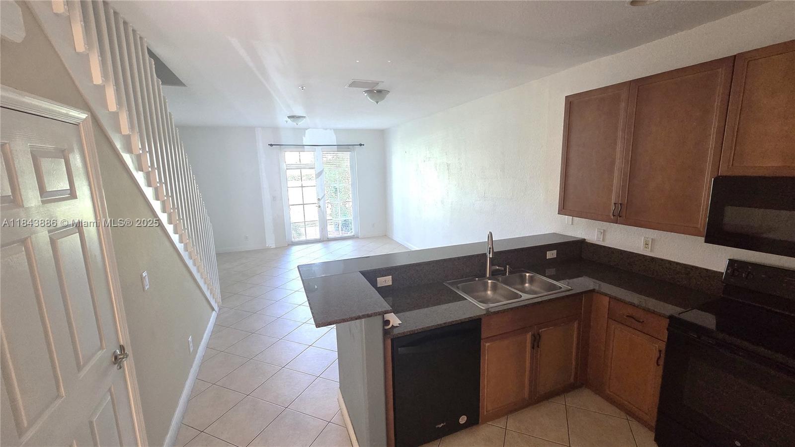 4605 Southwest 75th Way, Unit 4605 Davie, FL 33314 - Photo 6 of 42 a kitchen with granite countertop a sink and a black white cabinets