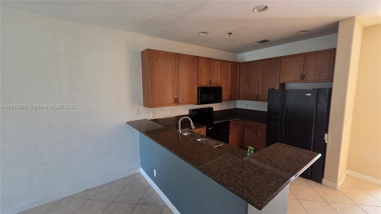 4605 Southwest 75th Way, Unit 4605 Davie, FL 33314 - Photo 8 of 42 a kitchen with a sink a microwave a refrigerator and a cabinets