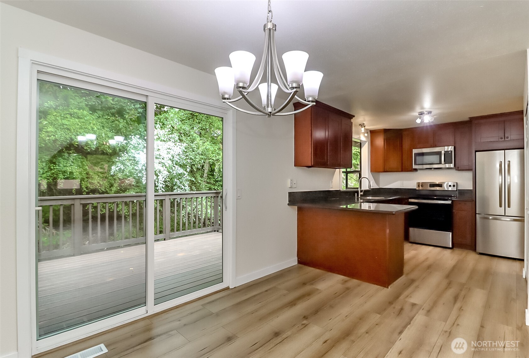 20015 108th Avenue Northeast Bothell, WA 98011 - Photo 14 of 28 a kitchen with stainless steel appliances granite countertop a refrigerator a sink dishwasher a stove and a dining table with wooden floor