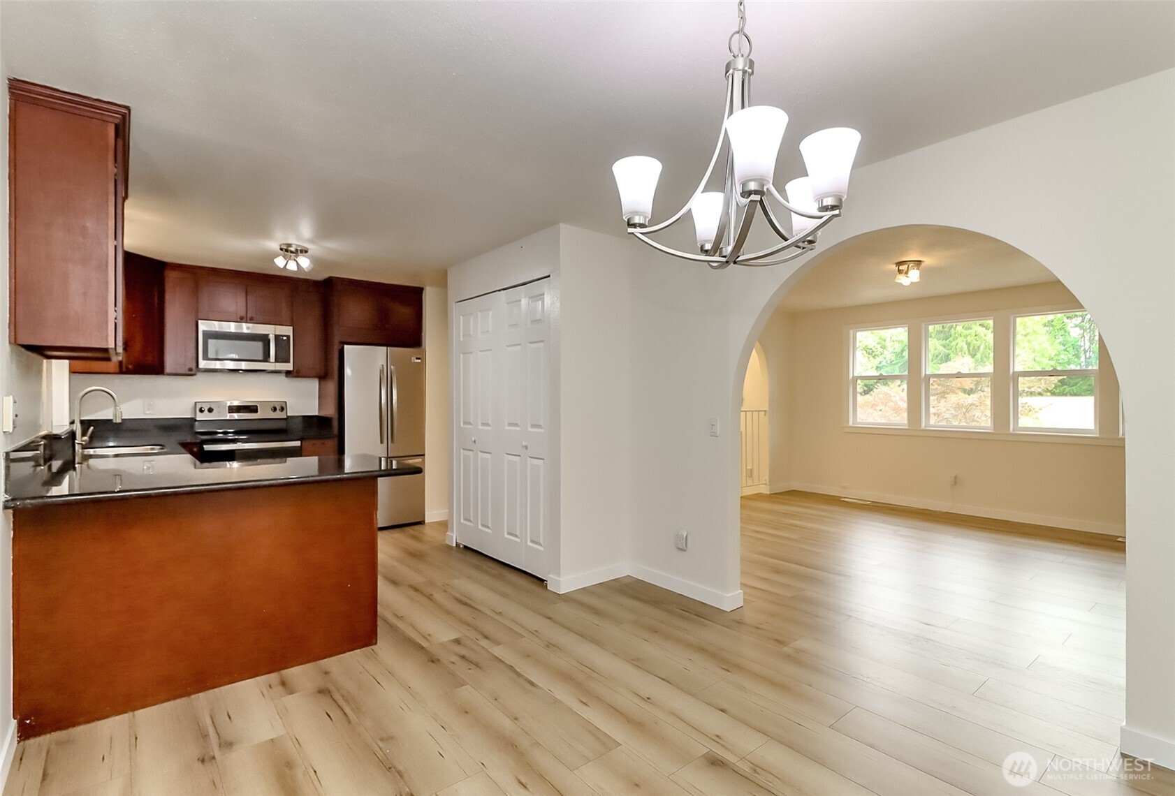 20015 108th Avenue Northeast Bothell, WA 98011 - Photo 27 of 28 a kitchen with stainless steel appliances granite countertop a refrigerator a sink dishwasher a stove and a dining table with wooden floor