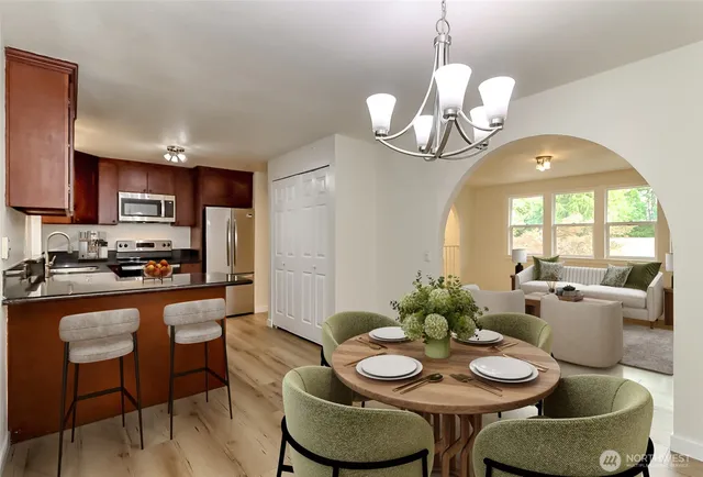a kitchen with stainless steel appliances granite countertop a kitchen island a stove a table and chairs