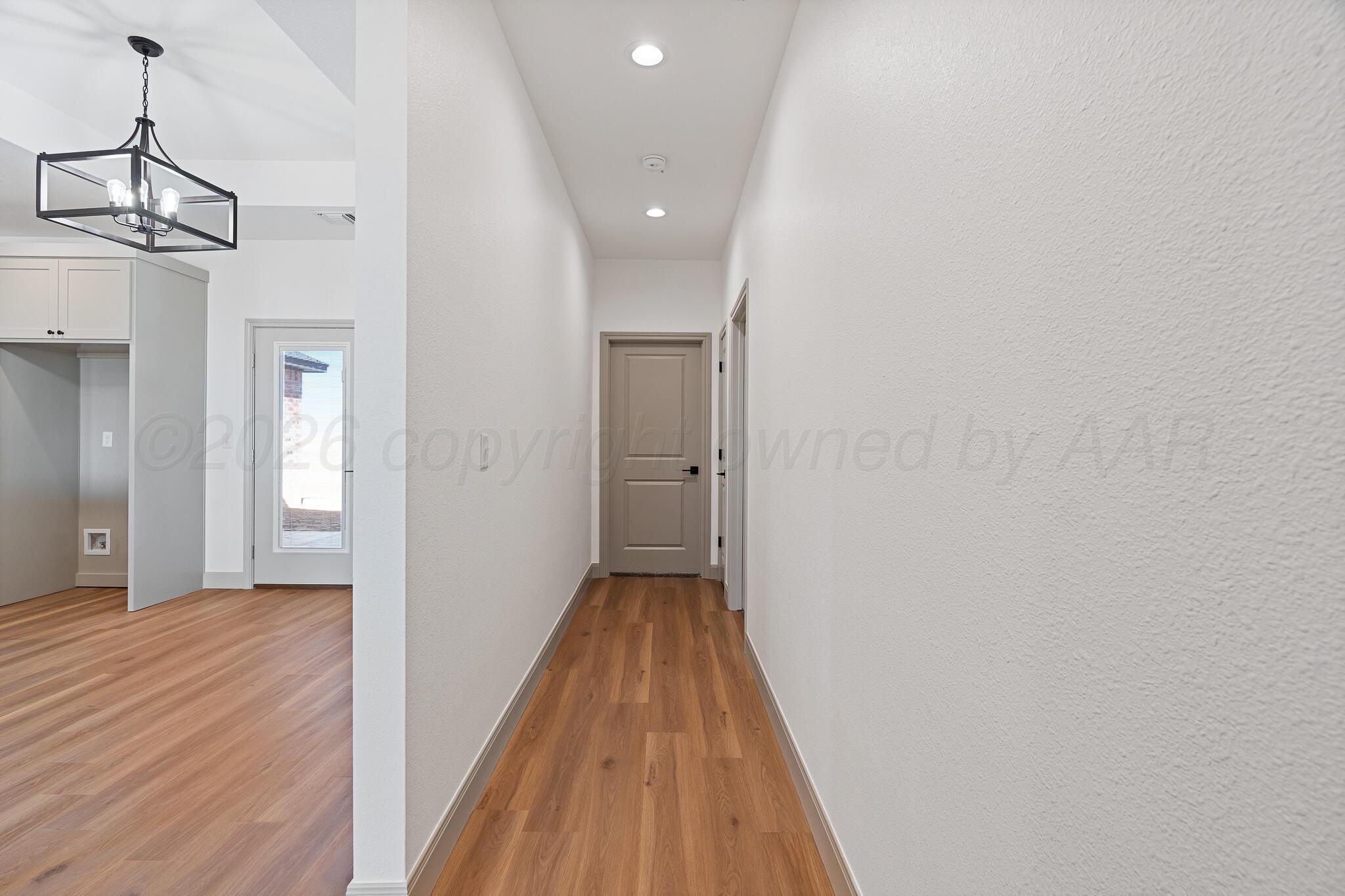 21700 Farm To Market Road 2219 Amarillo, TX 79119 - Photo 34 of 38 a view of a hallway with wooden floor and a bathroom