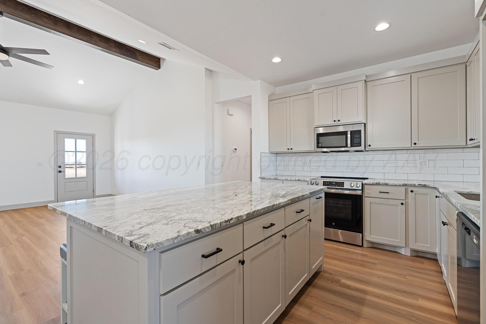 21700 Farm To Market Road 2219 Amarillo, TX 79119 - Photo 9 of 38 a kitchen with granite countertop white cabinets and stainless steel appliances