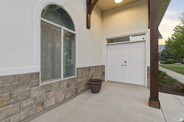 702 Alpine Highway Alpine, UT 84004 - Photo 75 of 83 Entryway featuring a double door with transom window, arched window, stone veneer siding, and stucco finish