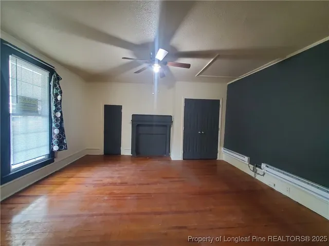 a view of an empty room with wooden floor