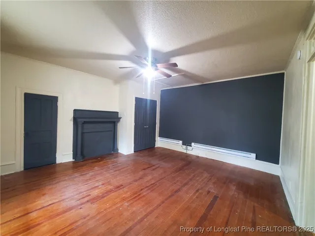 a view of empty room with wooden floor