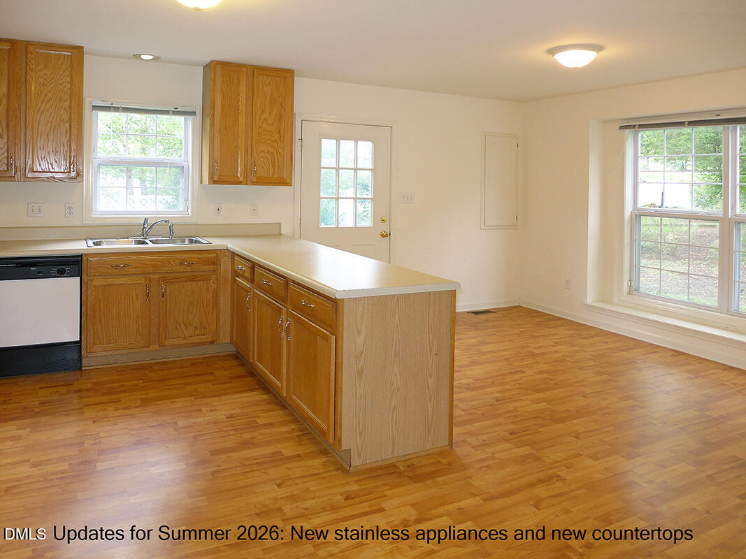308 Davie Road Carrboro, NC 27510 - Photo 8 of 21 a view of a kitchen with kitchen island a sink wooden floor and a large window