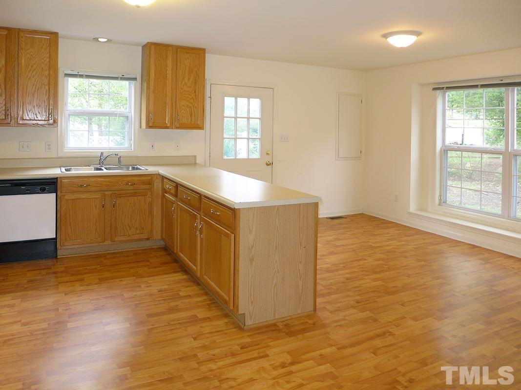 308 Davie Road Carrboro, NC 27510 - Photo 8 of 21 a view of a kitchen with kitchen island a sink wooden floor and a large window