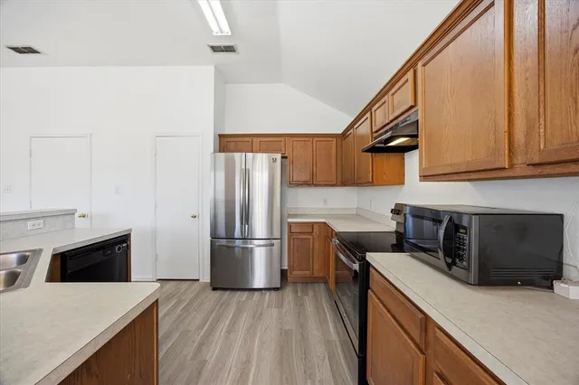 a kitchen with a refrigerator and a stove top oven