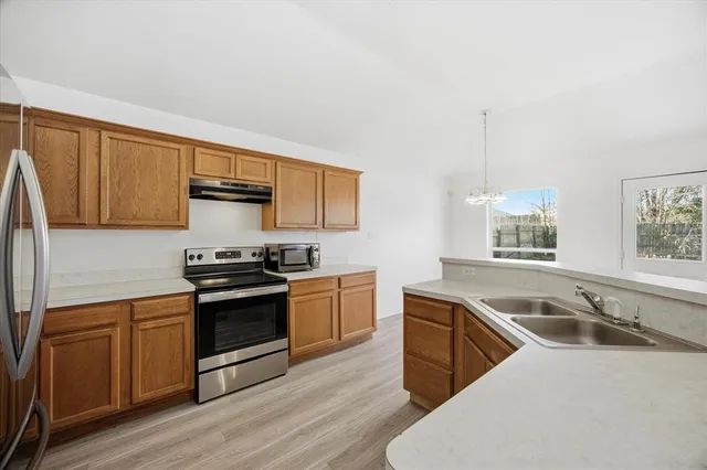 a kitchen with stainless steel appliances granite countertop a sink stove and microwave