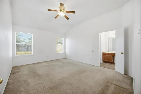 an empty room with windows and a ceiling fan