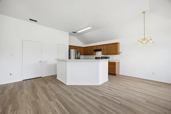 a view of a kitchen with wooden floor and electronic appliances