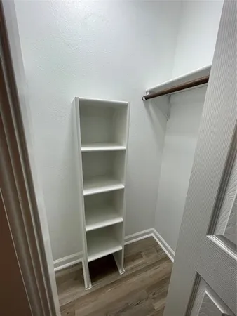 a view of walk in closet with empty racks