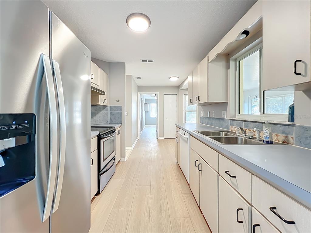 10583 Southwest 62nd Ter Road Ocala, FL 34476 - Photo 17 of 59 a kitchen with stainless steel appliances a refrigerator sink and white cabinets