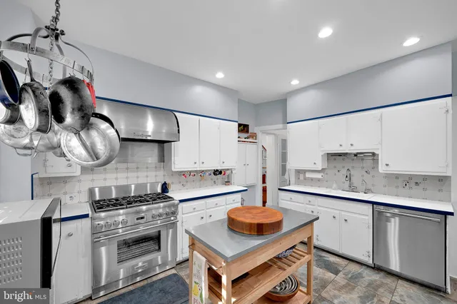 a kitchen with stainless steel appliances a stove a sink and a refrigerator