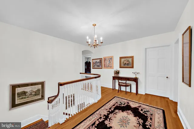a view of a livingroom with furniture a bedroom wooden floor and windows