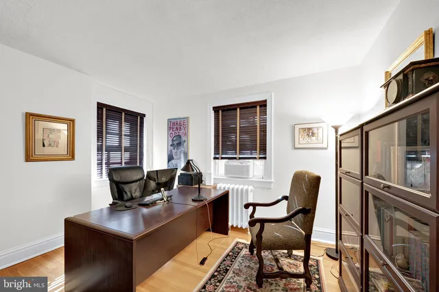 a view of a workspace with furniture and a window