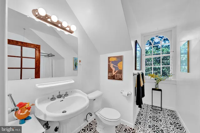 a bathroom with a sink a toilet and a mirror