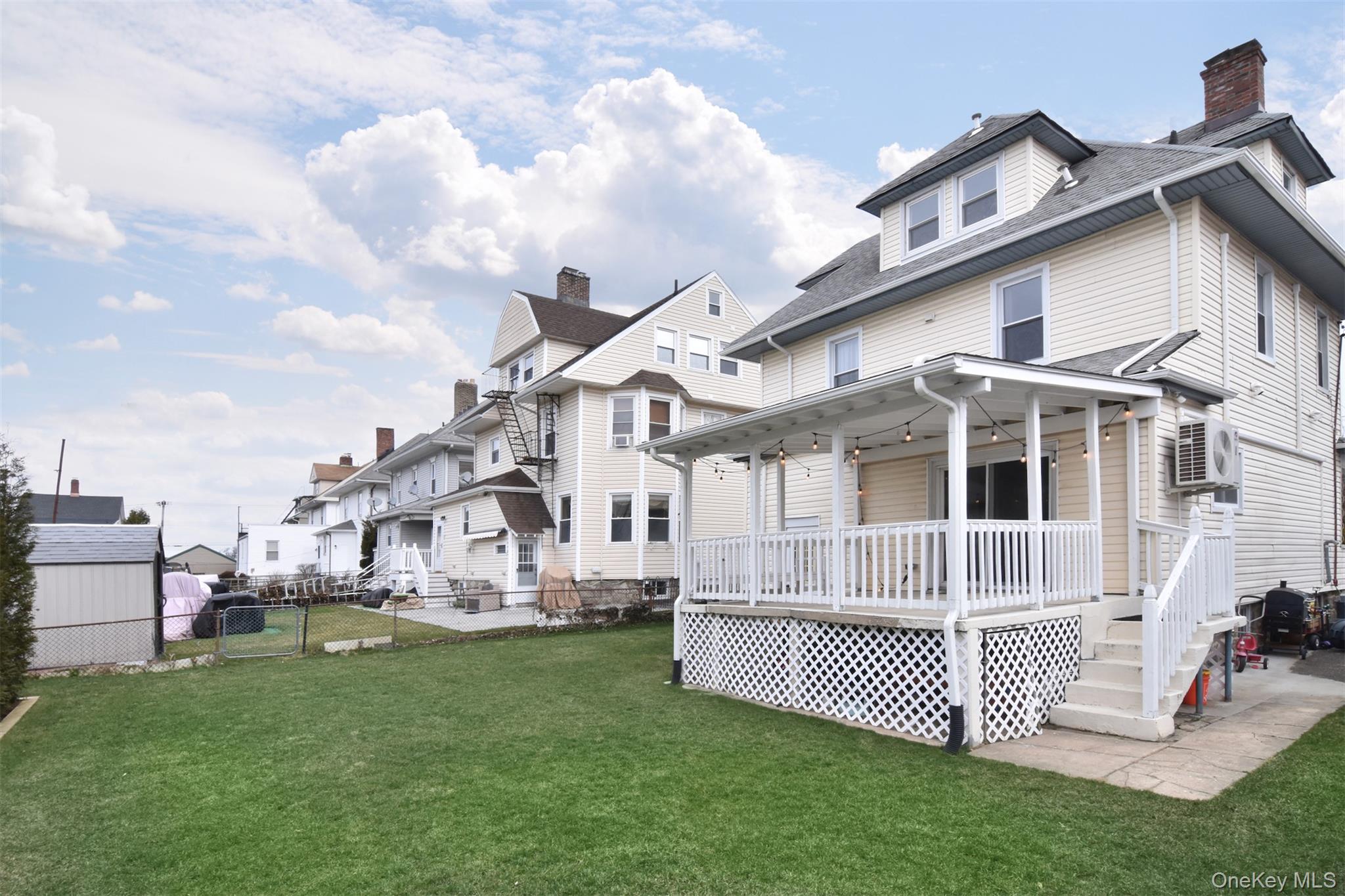 16 Badeau Place New Rochelle, NY 10801 - Photo 23 of 27 a view of a white house with a big yard and large trees