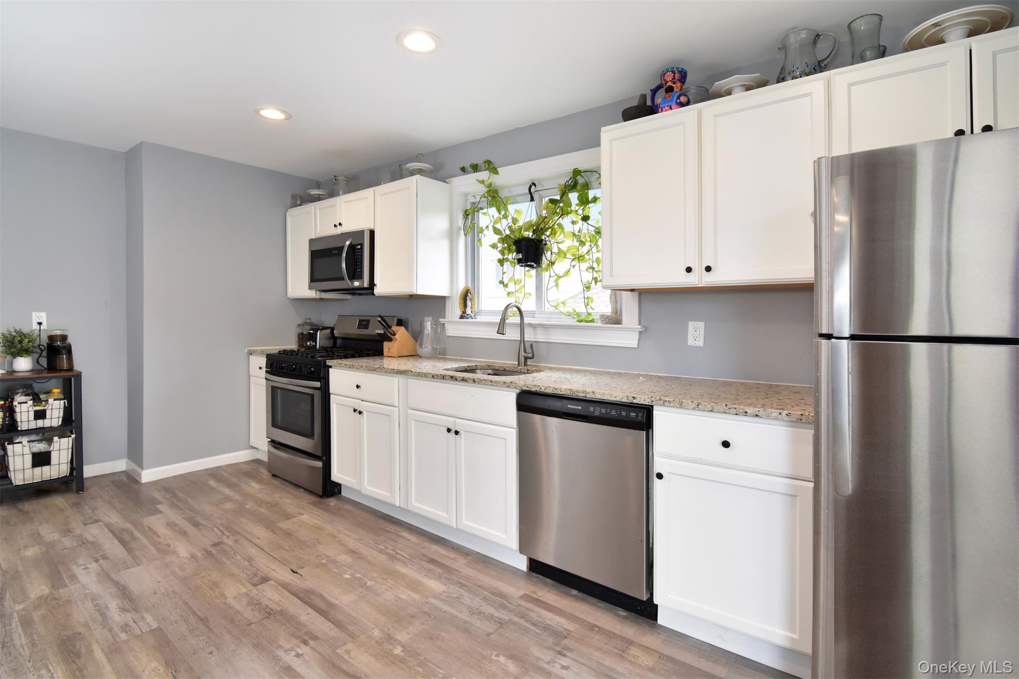 16 Badeau Place New Rochelle, NY 10801 - Photo 6 of 27 a kitchen with granite countertop a refrigerator sink stove and white cabinets