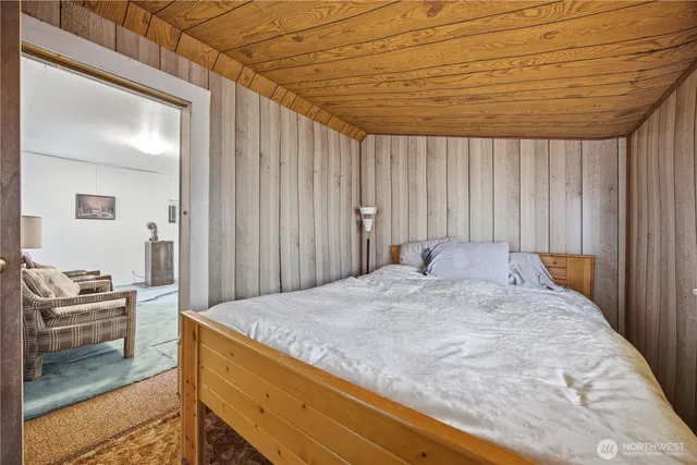 a bed sitting in a spacious bedroom next to a window