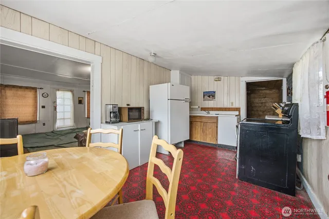a kitchen with stainless steel appliances wooden floor and a refrigerator