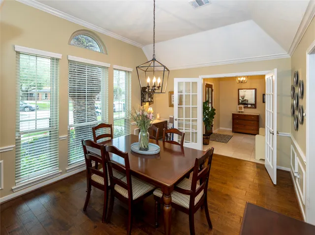 a dining room with furniture wooden floor a chandelier and a rug