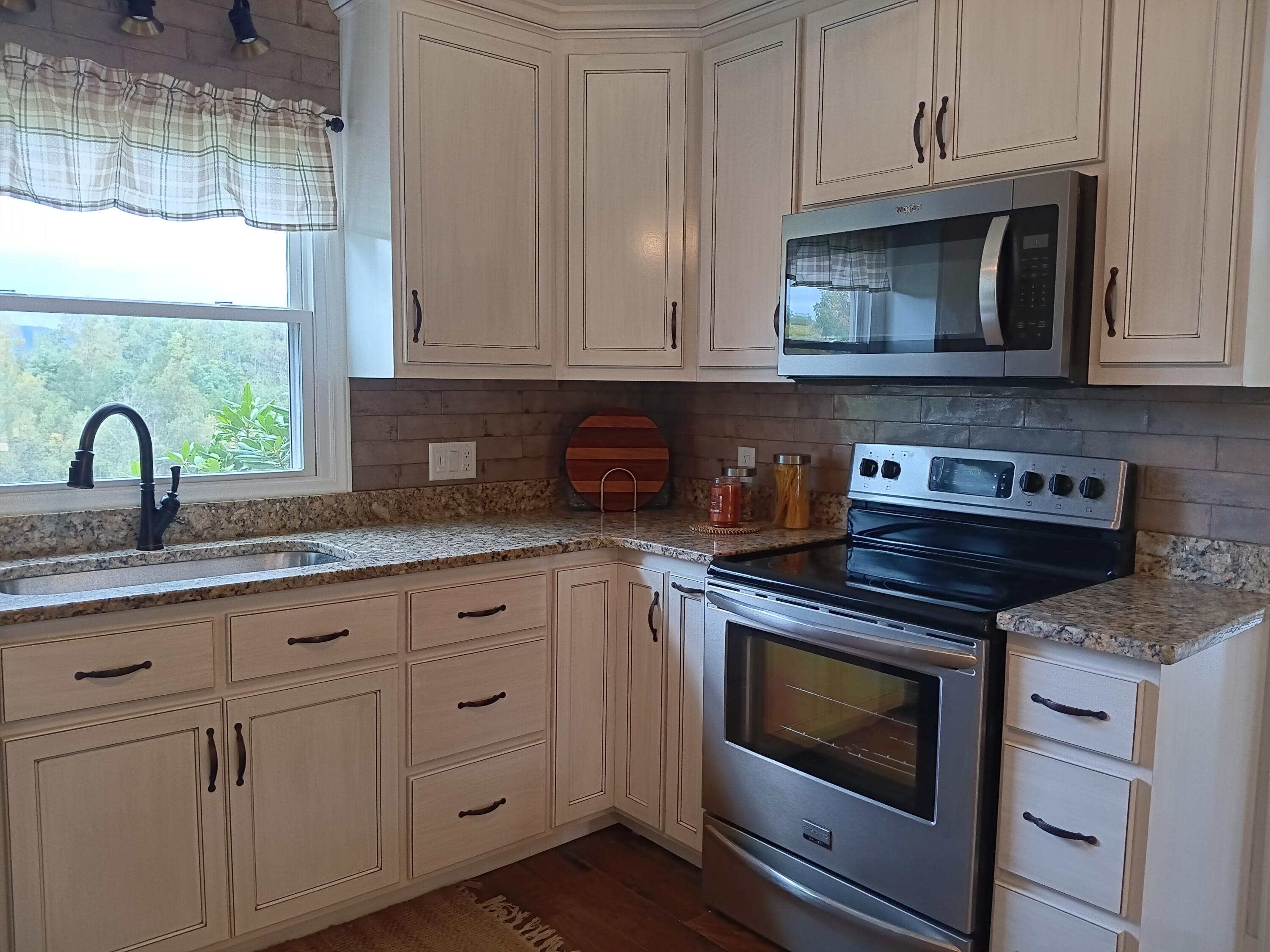 6000 Ferrum Mountain Road Callaway, VA 24067 - Photo 25 of 58 a kitchen with granite countertop white cabinets and appliances