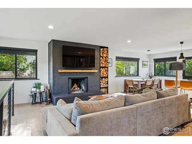 a kitchen with stainless steel appliances kitchen island a table chairs in it and wooden floors