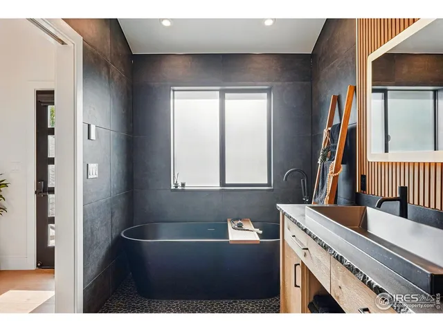 a spacious bedroom with a bed a couch and a potted plant