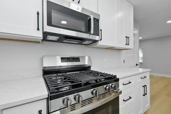 a stove top oven sitting inside of a kitchen