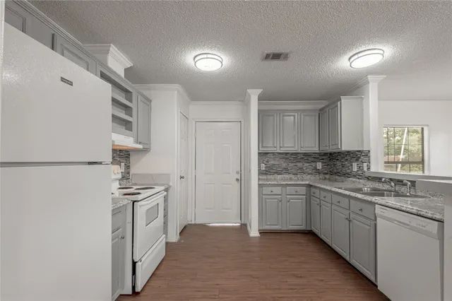 a kitchen with white cabinets and white appliances