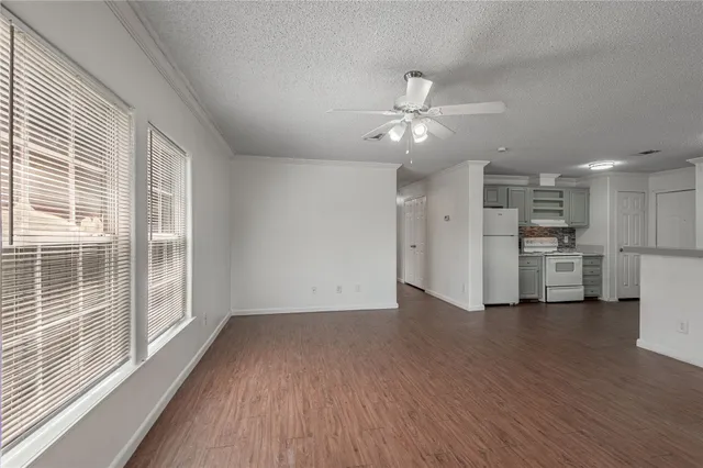a view of a kitchen with wooden floor and a ceiling fan