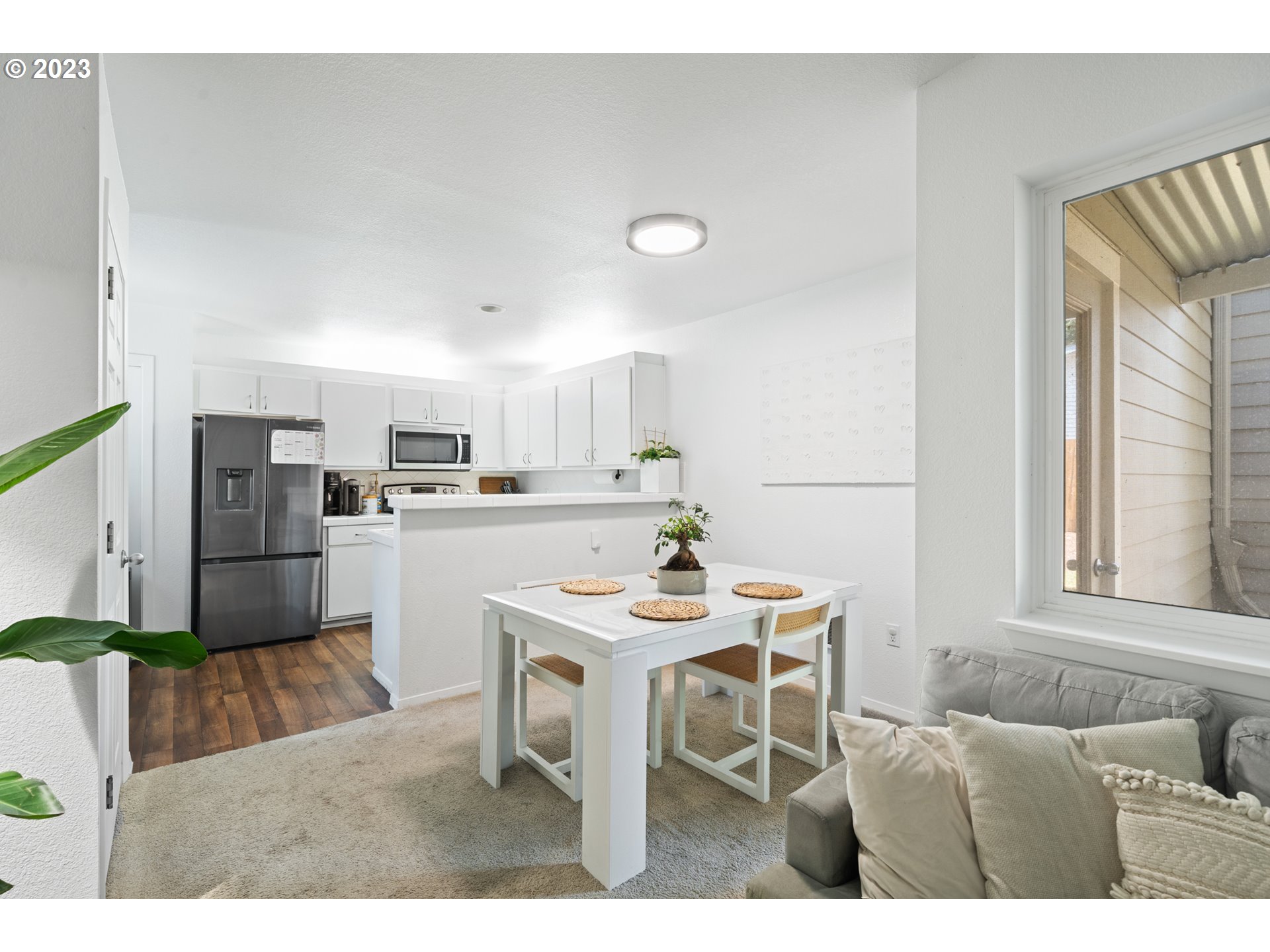 5225 Jean Road, Unit 309 Lake Oswego, OR 97035 - Photo 6 of 26 a kitchen with a refrigerator a stove a sink dishwasher with a dining table and chairs