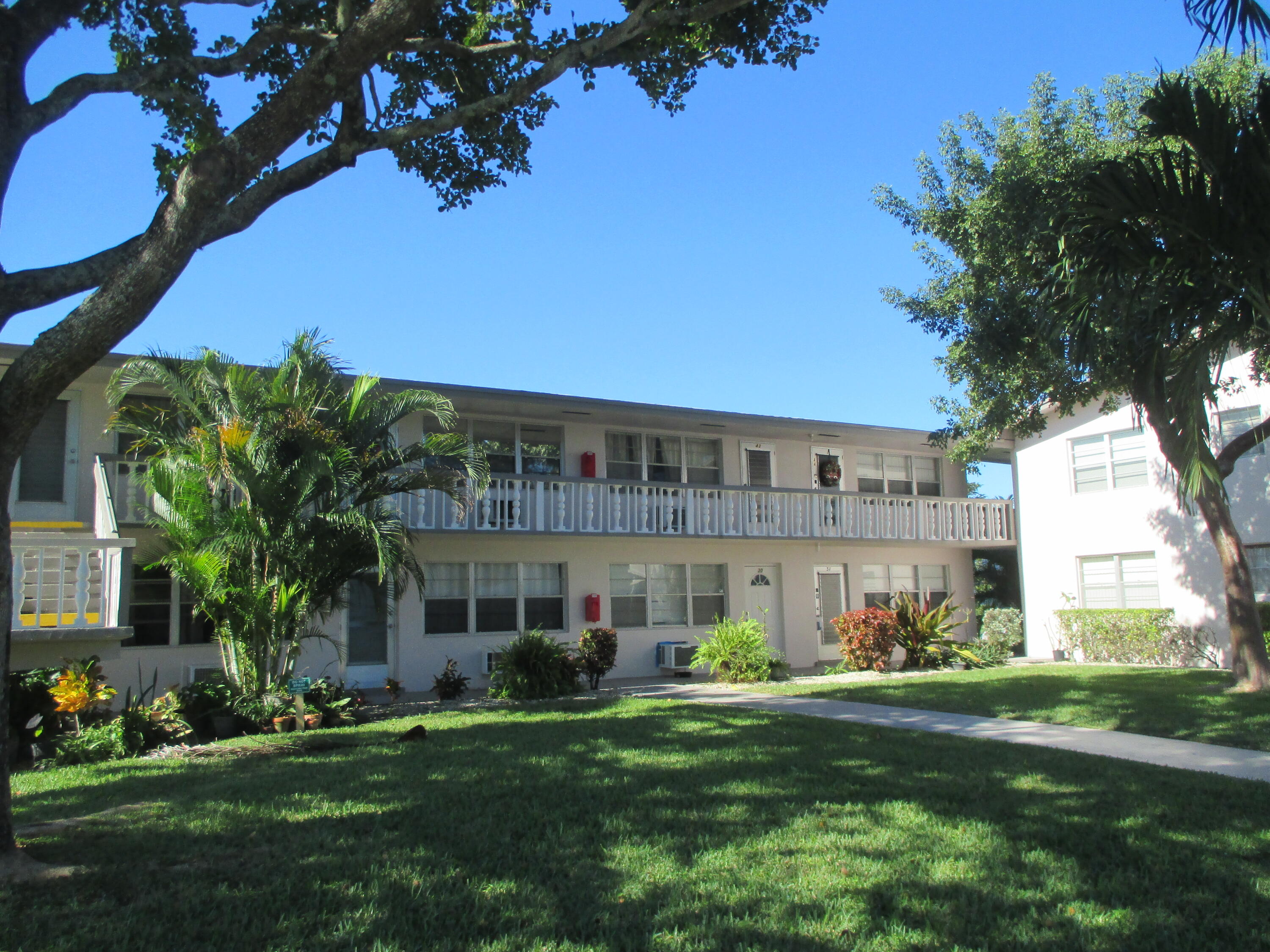 a front view of a house with a garden and yard