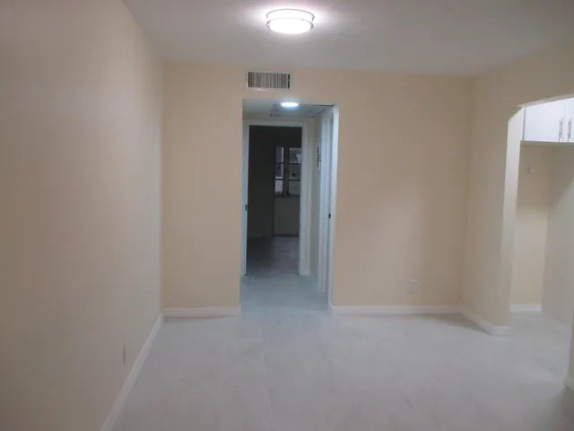 a view of an empty room with closet and wooden floor
