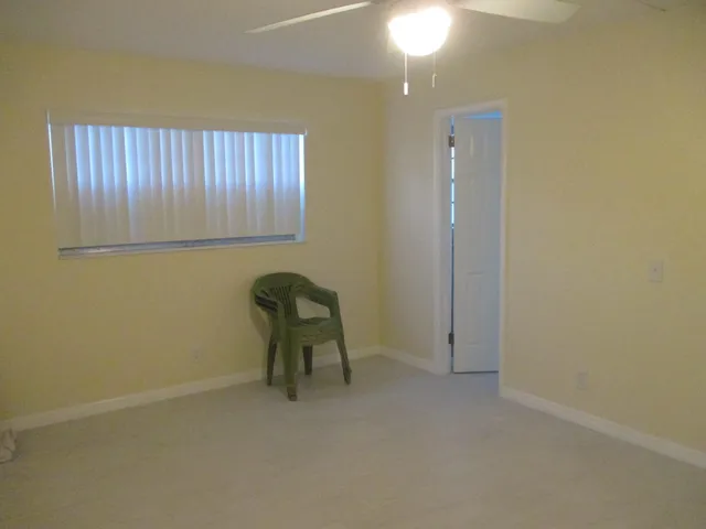 a view of a room with a chair and potted plant on th wall