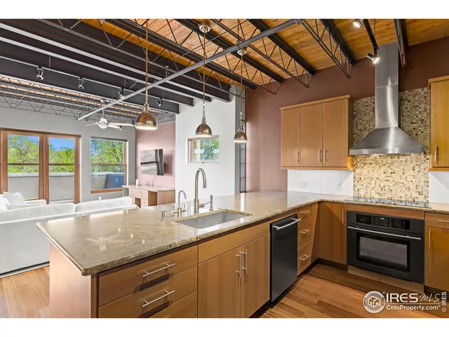 a kitchen with stainless steel appliances granite countertop a sink and a refrigerator