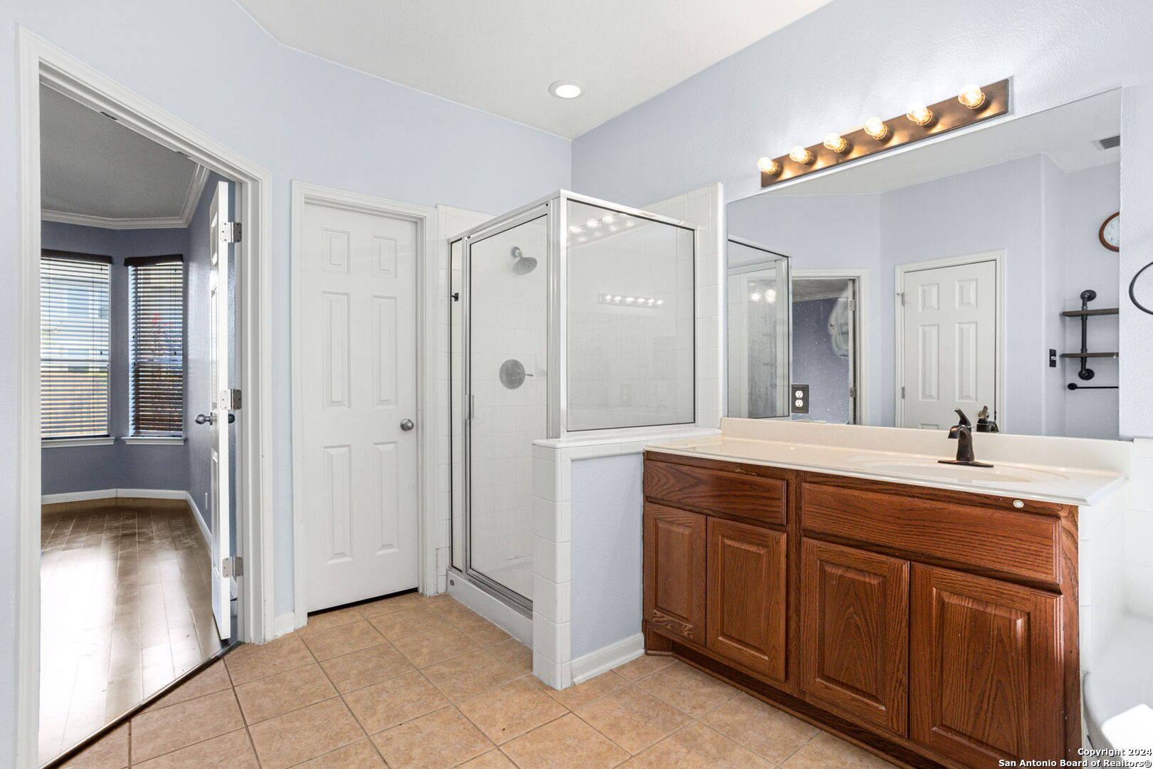 3415 Highline Trail San Antonio, TX 78261 - Photo 10 of 21 a spacious bathroom with a double vanity sink a large mirror and shower